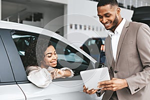 African American Woman Buying Car In Auto Dealership Center