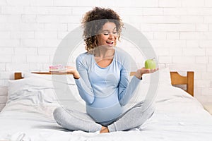 African-american woman choosing between healthy and junk food