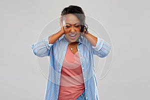 African american woman closing ears by hands