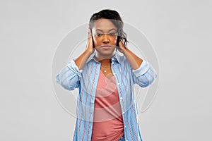 African american woman closing ears by hands