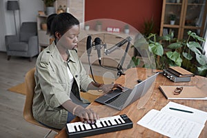 African-American Woman Composing Music at Home