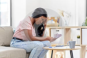 African american woman counting money at home