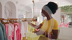 African american woman customer holding shopping bags and clothes at clothing store