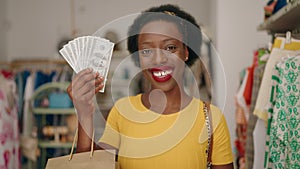 African american woman customer holding shopping bags and dollars at clothing store