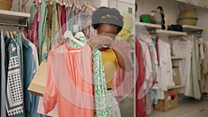African american woman customer smiling confident holding clothes at clothing store