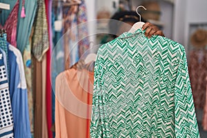 African american woman customer smiling confident holding clothes at clothing store