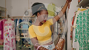 African american woman customer smiling confident holding handbag at clothing store