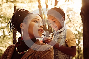 African American woman with daughter in park.