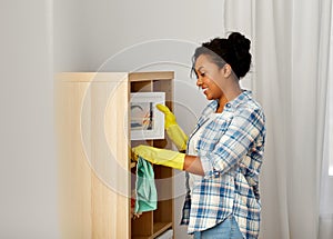 African american woman dusting and cleaning home
