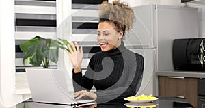 African american woman e learning using computer webcam chat makes notes.