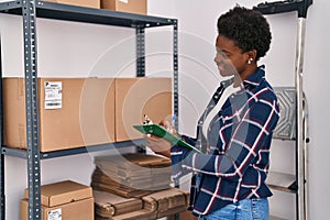 African american woman ecommerce business worker writing on clipboard at office