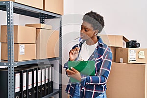 African american woman ecommerce business worker writing on clipboard at office