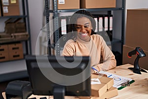 African american woman ecommerce business worker writing on clipboard at office