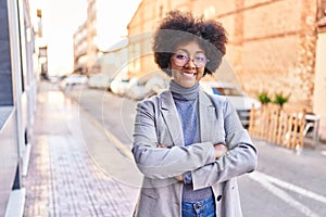 African american woman executive smiling confident standing with arms crossed gesture at street