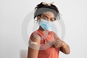 African american woman with face mask posing after immunization, closeup