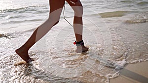 African american woman feet walking with surfboard on ocean beach. Black female surfer goes with surf board. Multiethnic