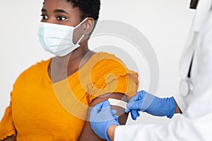 African American Woman Getting Vaccinated Against Covid-19, White Background, Cropped