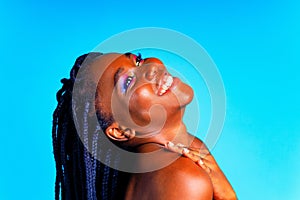 african american woman with gorgeus bright color make up feels proud and self confident in blue wall studio background