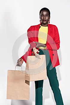 african american woman with hand on mannequin and shopping bags