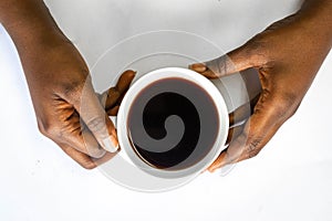 African American woman hands holding a white cup of coffee. Black Female hands holding a hot cup of coffee with foam