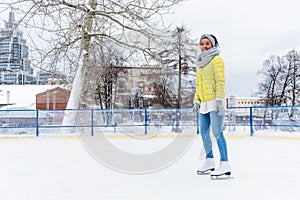 African american woman having figure ice skating on ice rink. Attractive African woman doing figure skating