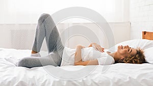 African-american woman having fun and laughing on bed