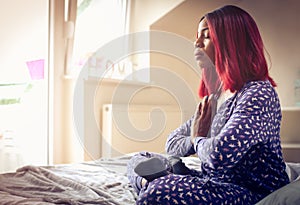 African American woman having meditation in bed at morning.