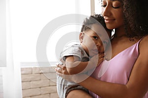 African-American woman  her baby at home. Happiness of motherhood