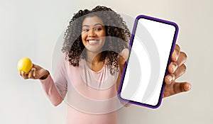 African American Woman Holding Cell Phone and Apple