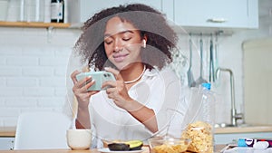 African American woman holds smartphone horizontally plays games online