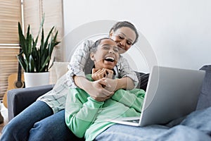 african american woman hugging laughing daughter