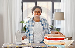 African american woman with ironed linen at home