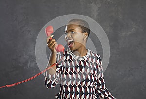 African american woman irritated and angrily shouting into the phone arguing with the operator.