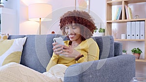African American woman laughing while chatting online on a dating app. Happy black female texting on a phone while