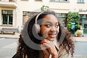 African american woman listening to music with headphones outdoors