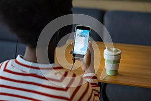 African-American woman listening to podcast from her smartphone