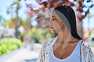 African american woman looking to the side with serious expression at park