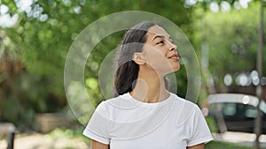 African american woman looking to the sky with serious expression at park