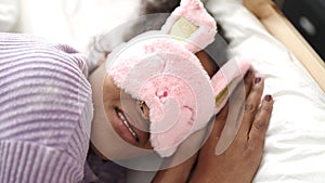 African american woman lying on bed wearing sleep mask sleeping at bedroom