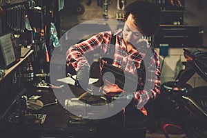 African american woman mechanic repairing a motorcycle in a workshop