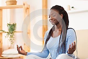 African American Woman Meditating In Bed At Home