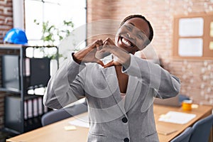 African american woman at the office smiling in love showing heart symbol and shape with hands