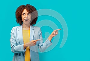 African American woman office worker in jacket pointing empty space ad isolated on blue color background, copy space