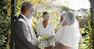 African american woman officiating wedding ceremony of senior biracial couple in garden, slow motion