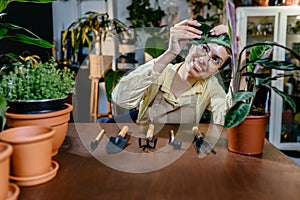 African American woman owner an ornamental garden with assistant using chart board to check the plants on a shelf in a