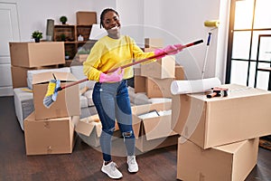 African american woman playing mop as a guitar cleaning at new home