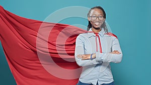 African american woman posing as superhero with red flying cape