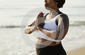 African American woman practicing yoga at the beach