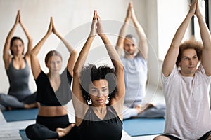 African American woman practicing yoga at group lesson, Padmasana exercise