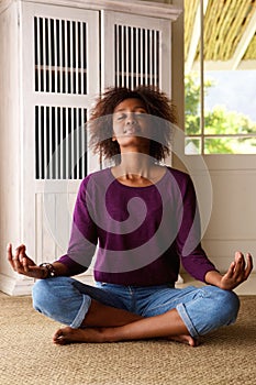 African american woman practising yoga at home